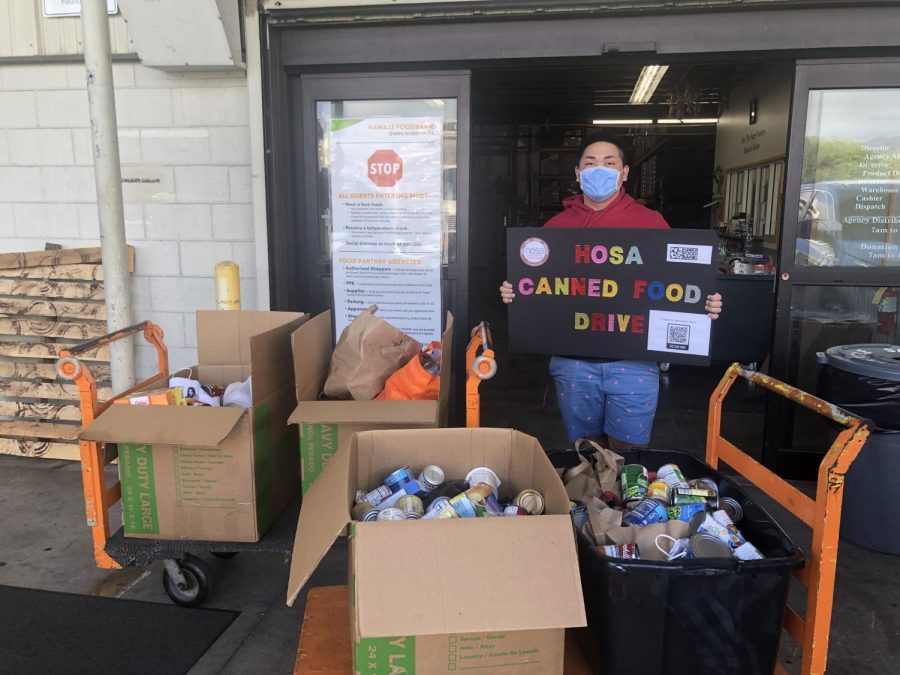 President of CUH HOSA Kelvin Manganaan delivers donated canned goods to Hawaii Food Bank.