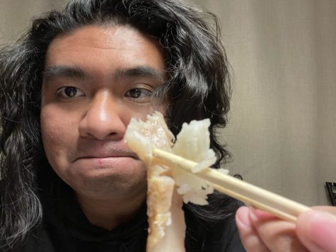Staff writer Albert Respicio gets ready to try a piece of sushi.