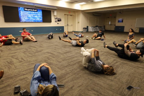 Students gathered in a circle for a series of stretches with fitness influencer and online coach Jeremy Sry.