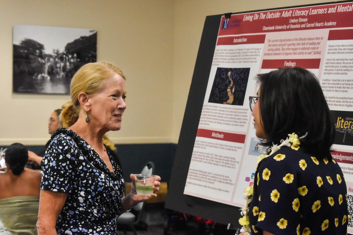 Lindsey Dimaya (right) presents her research to Lynn Babington, President of Chaminade University.